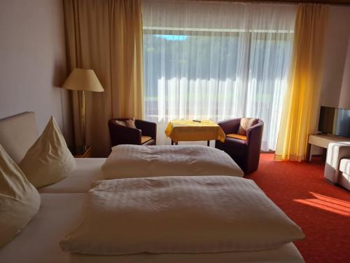 a hotel room with two beds and a table at Waldpension Rabeneck in Waischenfeld