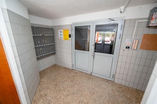 a bathroom with white tiled walls and a door at Apartma Golob in Maribor