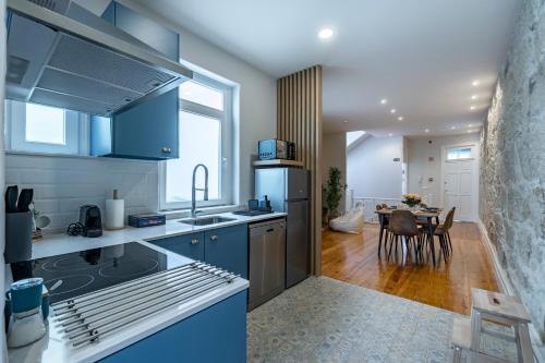 a kitchen with blue cabinets and a dining room at ApartmentsPorto - Porto Dukes House in Porto
