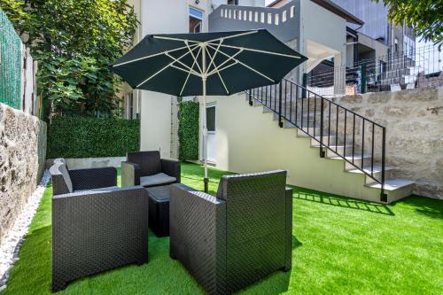 a patio with two chairs and an umbrella at ApartmentsPorto - Porto Dukes House in Porto