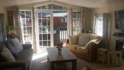 a living room with a couch and a coffee table at Jasper Lodge in Beautiful Glendevon Country Park Perthshire Scotland in Glendevon