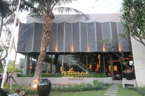 a building with a palm tree in front of it at Java Paragon Hotel & Residences in Surabaya