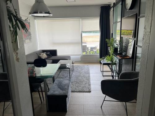 a living room with a couch and a table and chairs at 2 bedroom apartment at Knokke-Heist, near Zeebrugge, overlooking the lake in Knokke-Heist
