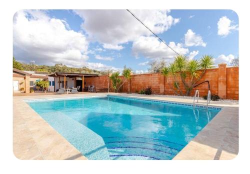 a swimming pool with blue water in a yard at Huerta Alegría in Casariche