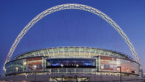 un gran edificio con un arco por la noche en Modern House with Free Parking near Wembley, en Londres