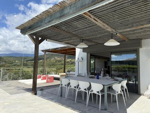 - un coin repas extérieur avec une table et des chaises dans l'établissement kaki, à Pinarellu