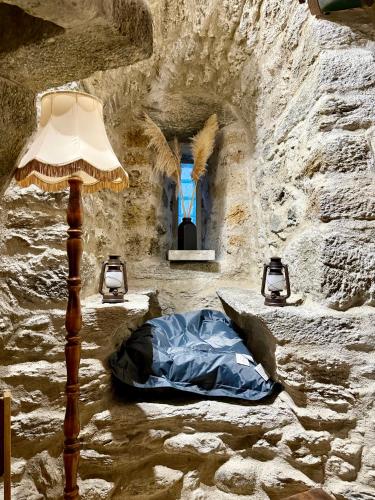 a lamp and a pillow in a stone room with a window at La tour du Château - Jacuzzi sur le toit in La Léchère