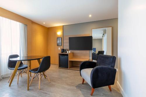 a room with a table and chairs and a television at Holiday Inn Sao Paulo Parque Anhembi by IHG in Sao Paulo