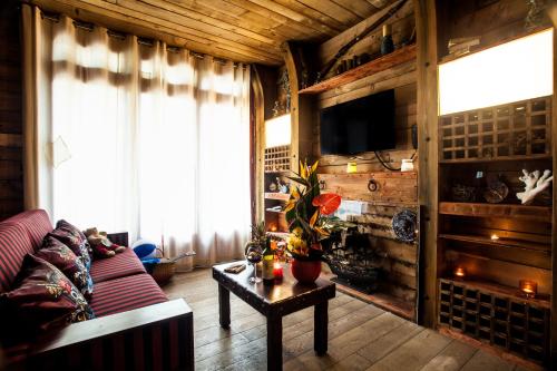 a living room with a couch and a tv and a table at Hôtel Cap Pirate in Cap d'Agde