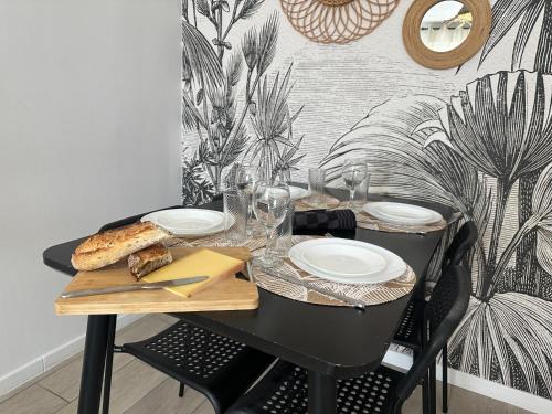 a black table with glasses and a plate of food at Le Bohème - Appartement proche gare et commerces in Gisors