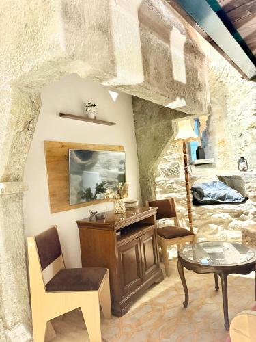 a room with a table and chairs and a stone wall at La tour du Château - Jacuzzi sur le toit in La Léchère
