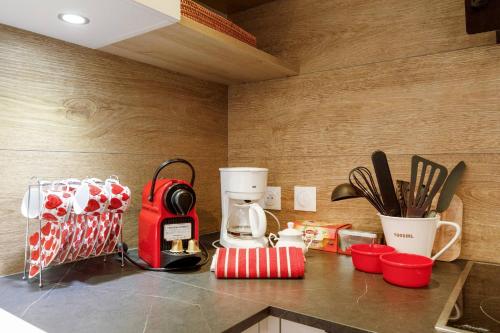 - un comptoir de cuisine avec une cafetière rouge et des ustensiles dans l'établissement Juan les pins confort et commodites, à Antibes