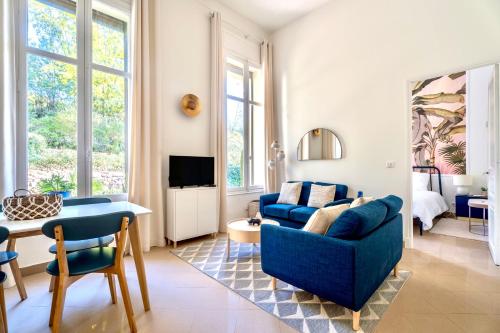 un salon avec un canapé bleu et une table dans l'établissement 3 pièces élégant - Clim Terrasse Parking - Plage, à Saint-Raphaël