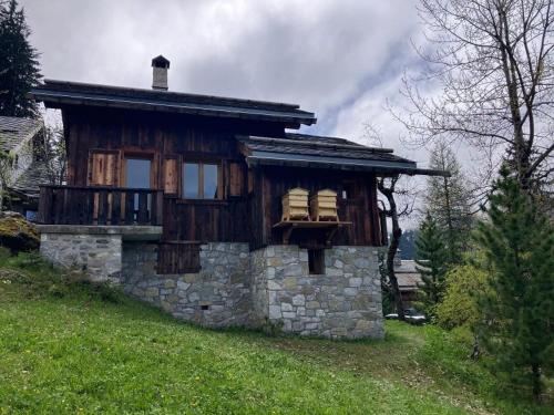 Cette petite maison en pierre dispose d'un balcon sur une colline. dans l'établissement Meribel Altitude1600 chalet 6 personnes en pleine nature au milieu des pistes, à Méribel