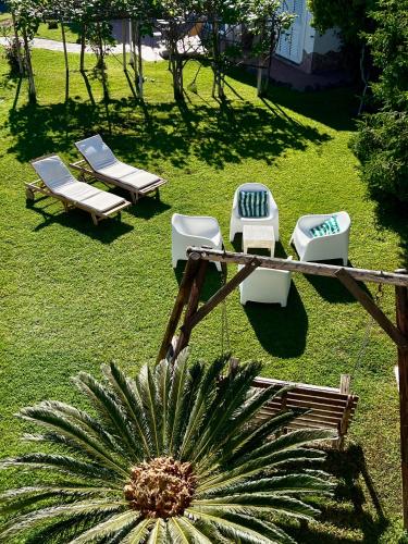a group of lounge chairs and a plant in a yard at Villa Joyosa Apartments in Ischia Town