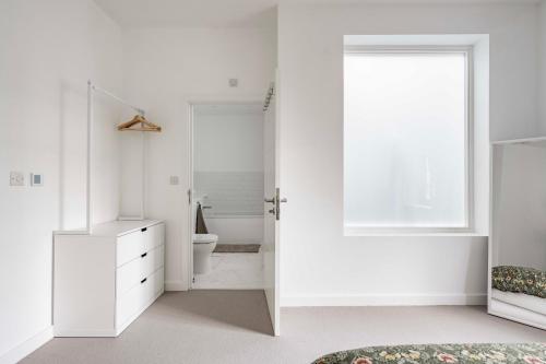 Un baño blanco con inodoro y ventana. en The Old Post Office, en Norwich