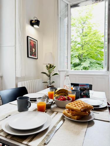 - une table avec des assiettes de petit-déjeuner dans l'établissement La Loge Urbaine - Cœur de Ville, à Avignon