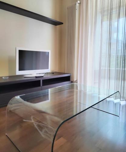 a living room with a tv and a glass table at Bluemar Dolcemare - 105mq in Cattolica