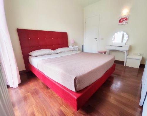 a bedroom with a red bed with a red headboard at Bluemar Dolcemare - 105mq in Cattolica