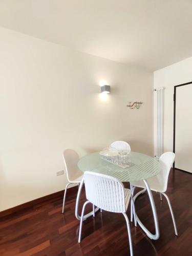 a dining room with a green table and white chairs at Bluemar Dolcemare - 105mq in Cattolica