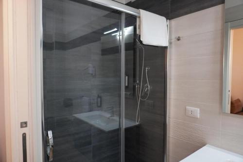a bathroom with a glass shower with a sink at Palazzo Simposio in Torremaggiore