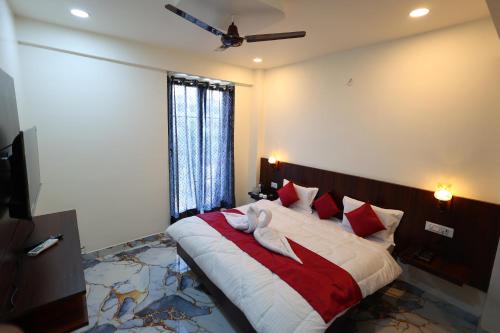 a bedroom with a large bed with red and white pillows at The Brij Vista in Mathura