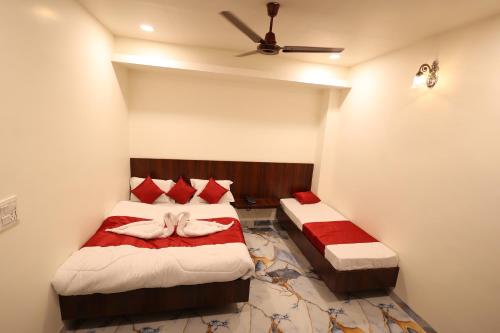 a bedroom with two beds and a ceiling fan at The Brij Vista in Mathura