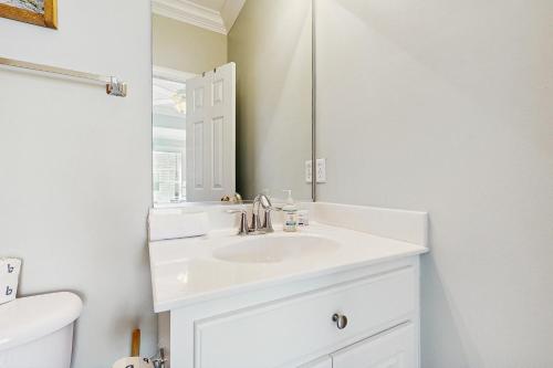 un bagno bianco con lavandino e specchio di King Cotton Villa 17 a Edisto Beach