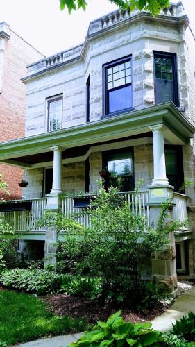 a large white house with a porch and windows at Comfy Garden Suite in Andersonville in Chicago