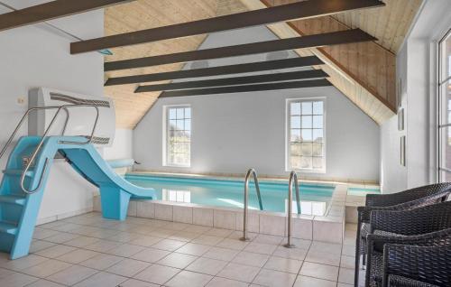 a swimming pool with a blue slide in a building at Gorgeous Home In Harboøre With Sauna in Harboør