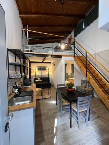 a kitchen and dining room with a table and a staircase at Donna Mariù in Catania
