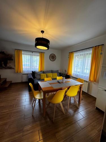 a living room with a table and yellow chairs at Słoneczna Polana in Solina