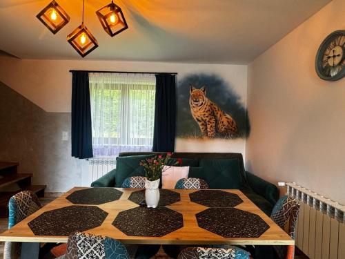 a living room with a table and a cat on the wall at Słoneczna Polana in Solina