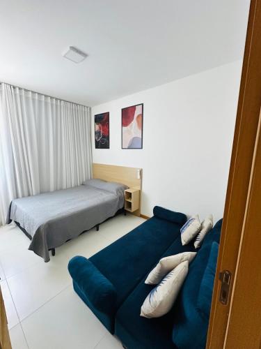 a bedroom with two beds and a couch at Casa da Alê in Camaçari