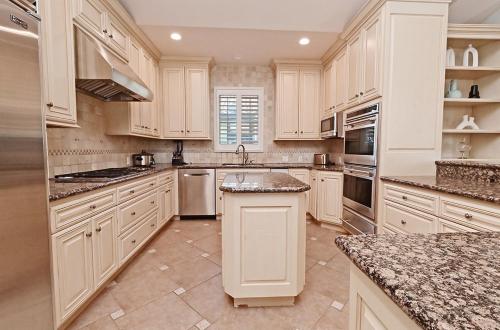 a large kitchen with white cabinets and granite counter tops at 2 BEDROOM & 3 BATH - SPACIOUS - 1900 ft2 or 176 m2 - WALK TO DWNTWN AND CLOSE TO Livermore, Dublin in Pleasanton
