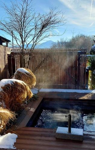 a swimming pool in a backyard with a wooden fence at Ferienhaus Berge und See mit Whirlpool und Sauna in Rimsting