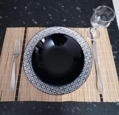 a plate on a table with a fork and a glass at ANNA'S HOME Ιωάννινα in Ioannina