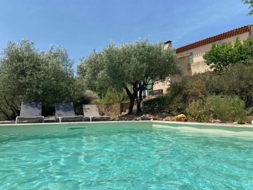 une piscine avec des chaises et des arbres ainsi qu'un bâtiment dans l'établissement PantaiaHomes - Clos de Susville - Vue Panoramique - Piscine - Jacuzzi, à Tavernes