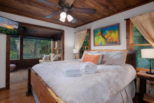 a bedroom with a bed with a ceiling fan and windows at Mountain Melody in Morganton