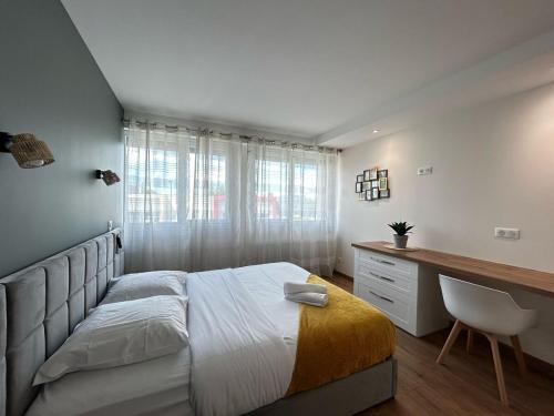 a bedroom with a bed with a desk and a chair at La Suite Vienne, chic et calme in Panazol