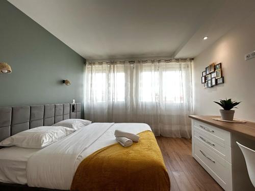 a bedroom with a large bed and a window at La Suite Vienne, chic et calme in Panazol