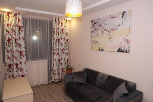 a living room with a couch and a painting on the wall at Syune Syunick Shinuhayr in Shinuhayr