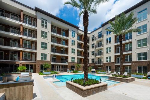 an apartment building with a swimming pool and palm trees at Downtown Modern Elegance Suite with Free Parking, Pool, WIFI and a King Bed in Houston