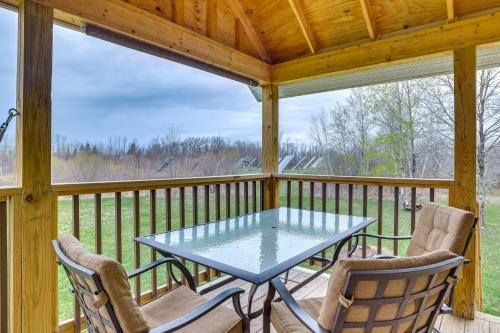 eine abgeschirmte Veranda mit einem Tisch und 2 Stühlen in der Unterkunft Cozy Solar-Powered Loft Walk to Lake Champlain! in Camp Maquam