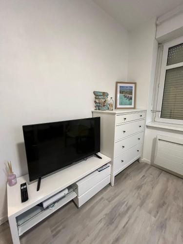 a living room with a flat screen tv on a white entertainment center at City APPARTEMENT EN 3 Lys in Saint-Louis