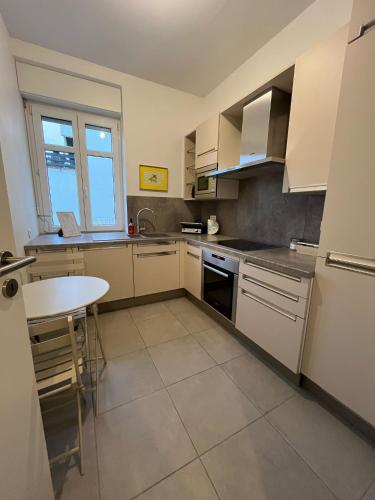 a kitchen with white cabinets and a table in it at City APPARTEMENT EN 3 Lys in Saint-Louis