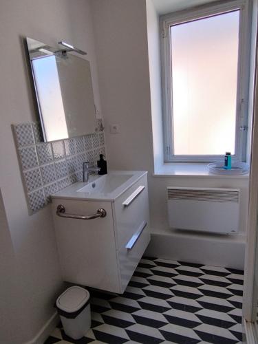 une salle de bain blanche avec un lavabo et une fenêtre dans l'établissement Escale Kernoa, à Paimpol