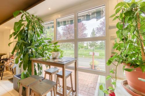 a room with plants and a table and a window at FASTHOTEL ROISSY CDG SUD - Claye Souilly in Claye-Souilly