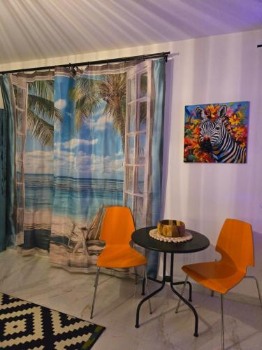 Una habitación con dos sillas y una mesa y un cuadro. en GDAŃSK by the Sea - PRESTIGE HOME SPA Apartments with a luxurious JACUZZI, SAUNA and an exclusive Massage Chair available in one of the apartments!, en Gdansk