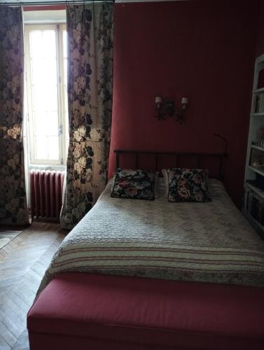 une chambre avec un grand lit aux murs rouges dans l'établissement Fenêtre sur vue, à Saignon